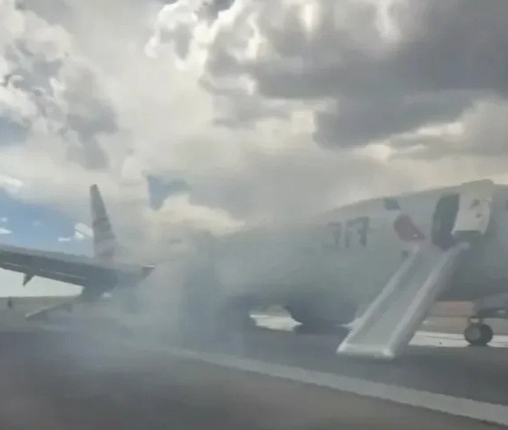 Moment 150 terrified passengers flee plane engulfed in smoke after landing gear issue sparked fire and injured one